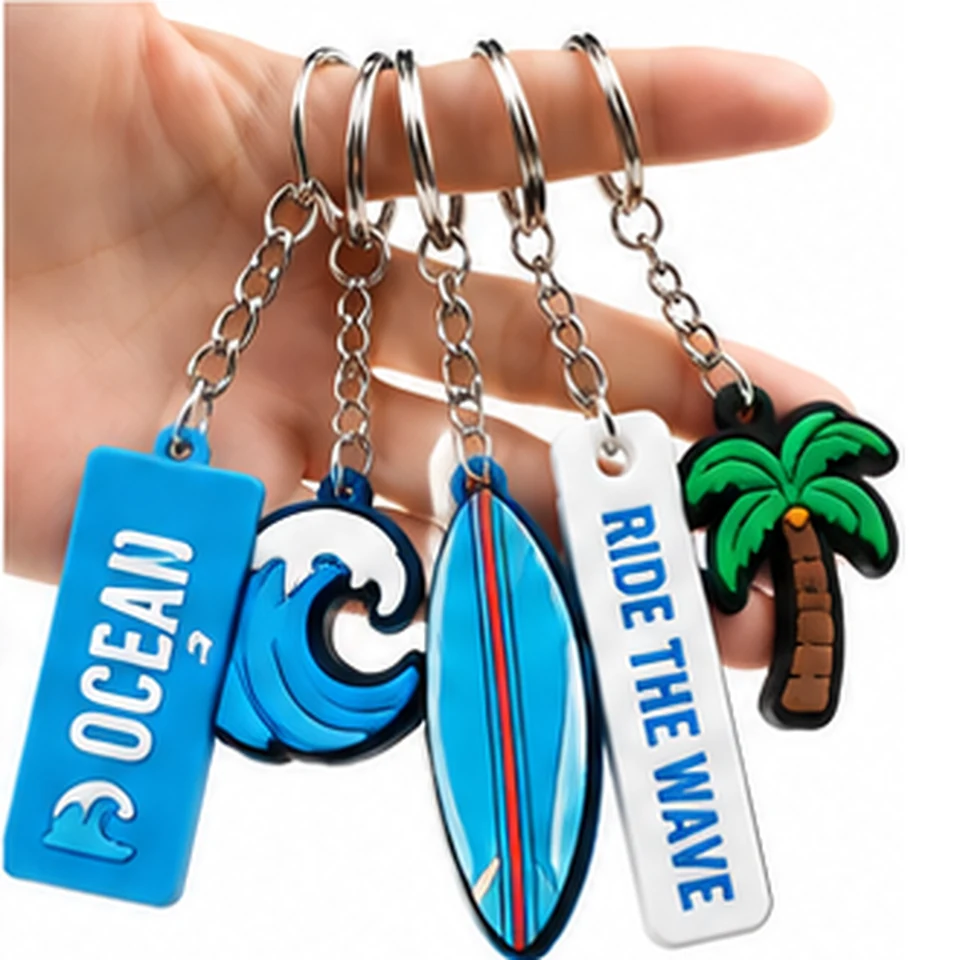 Five blue ocean-themed keychains with a wave, surfboard, palm tree and text tags held by their split rings